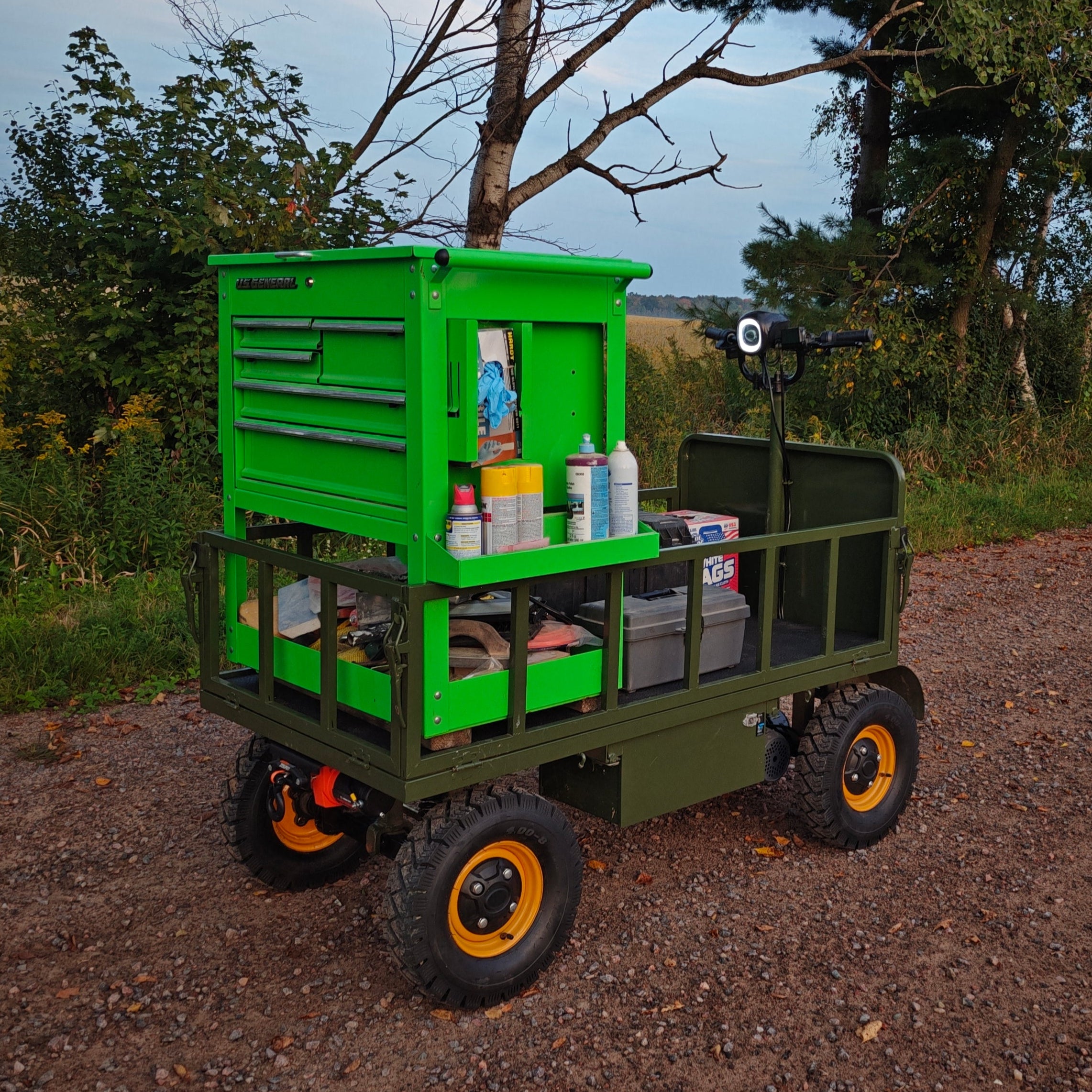 Green utility cart with tools and supplies outdoors